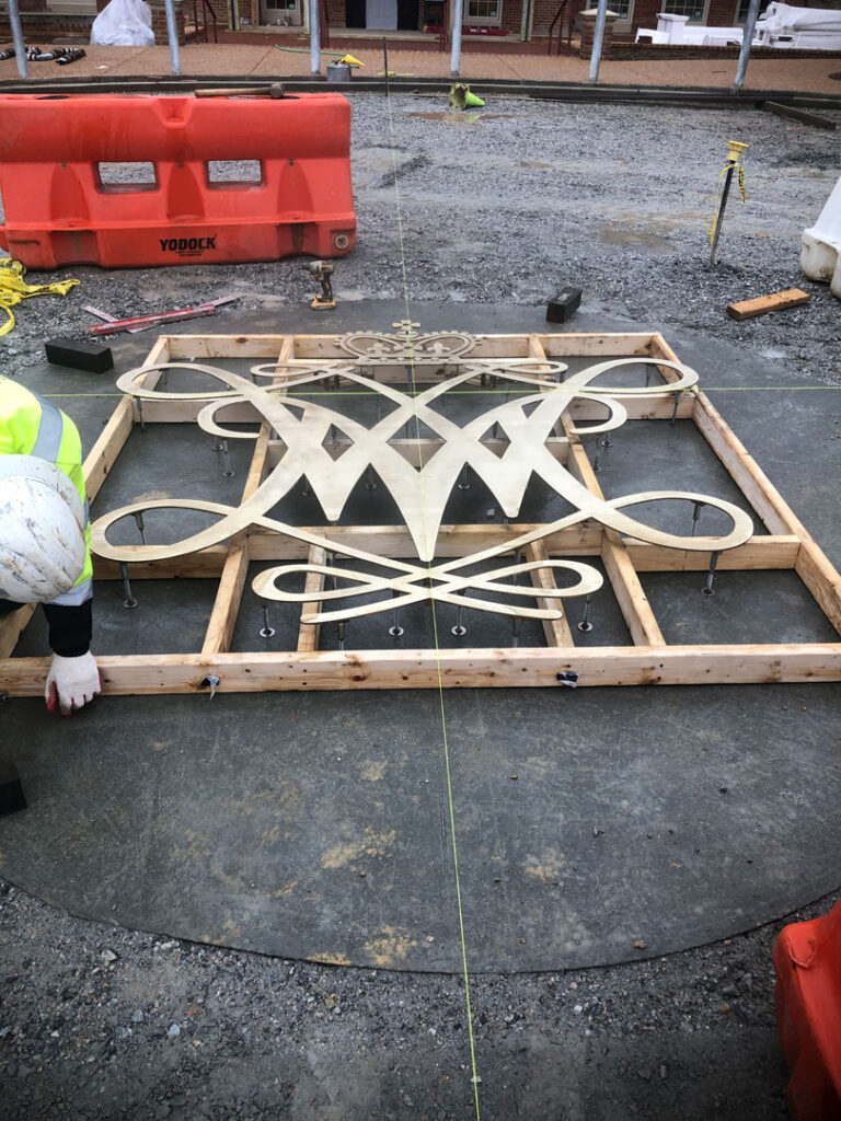 Worker preps a decorative insert to be placed in concrete